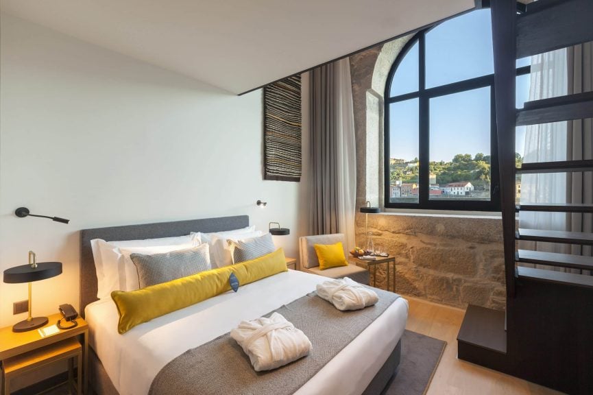 Vista Interior Da Suite Duplex Superior Com Cama De Casal, Grande Janela Para O Rio Douro E Escada De Acesso Ao Piso Superior Com Sala De Estar
